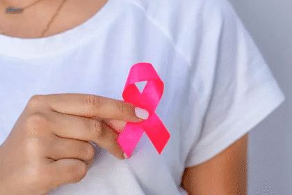 Mujer realiza autoexamen de mama durante campaña de prevención del cáncer.