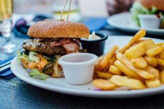 Hamburguesa con papas fritas, alimentos ricos en grasas y sal que aumentan el riesgo de enfermedades cardíacas.
